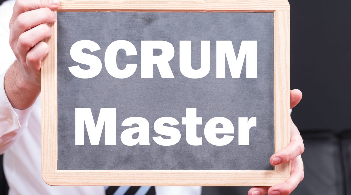 A businessman wearing a suit and holding a blackboard with the phrase SCRUM and SPRINT written on it